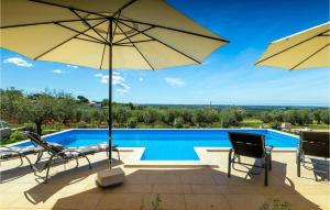 une piscine avec deux chaises et un parasol dans l'établissement Villa Carpe Diem, à Poreč