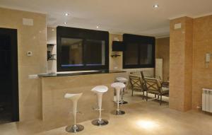 a room with a bar with stools and a television at Lovely Home In Santa Susanna With Wifi in Santa Susanna