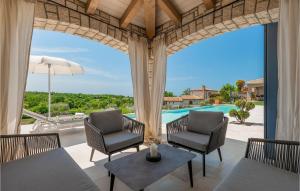 une terrasse avec 2 chaises, une table et une piscine dans l'établissement Villa Carinzia, à Poreč