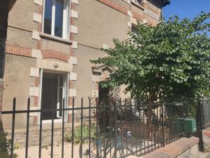 a fence in front of a building with a tree at Bel appart rénové avec terrasse in Saint-Avertin