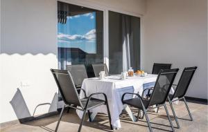 a white table with black chairs and a white tablecloth at Three-Bedroom Holiday Home In Brodarica in Brodarica