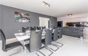 a dining room with a table and black chairs at Lovely Home In Perusic Donji With Wifi in Dušić
