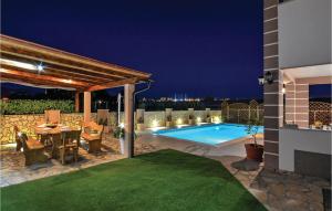 a patio with a table and a swimming pool at night at Gorgeous Home In Solin in Solin