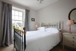 Un dormitorio con una gran cama blanca y una ventana en The Bridge Inn en Ratho