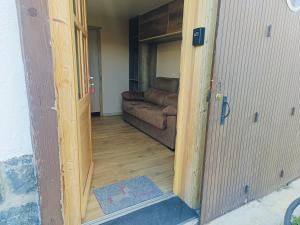a door leading into a living room with a couch at Studio au cœur de Cerdagne in Bourg-Madame