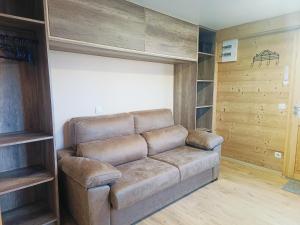 a brown couch in a room with wooden shelves at Studio au cœur de Cerdagne in Bourg-Madame +4 photos