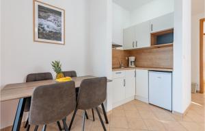 a kitchen and dining room with a wooden table and chairs at Vila Sidro in Košljun