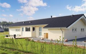 a small white house with a black roof at Holiday Home Sydals 11 in Skovby