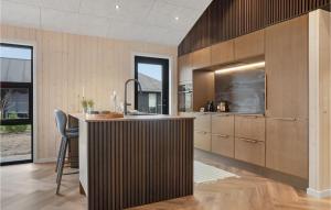 a kitchen with wooden cabinets and a bar with a stool at Cozy Home In Tarm With Sauna in Tarm