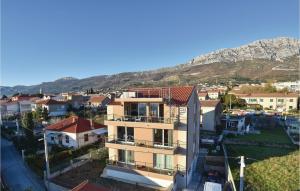 an apartment building with a mountain in the background at Three-Bedroom Apartment In Kastel Gomilica in Kaštela