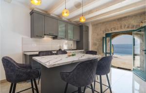 une cuisine avec un grand îlot et des tabourets de bar dans l'établissement Awesome Home In Jesenice With Kitchen, à Jesenice