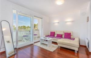 a living room with a couch and a table with purple pillows at Lovely Apartment In Malinska With Wifi in Malinska