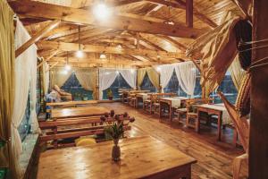 a large room with wooden tables and benches at TES Hotel in Osh