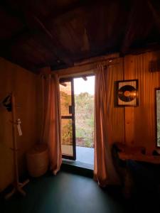een kamer met een deur naar een kamer met een raam bij Aroma Home - Eco-Cabins on a Coffee Farm in Arusha