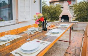 einen Holztisch mit Tellern, Weingläsern und Blumen in der Unterkunft Apartment Stablinec Iv,br, Cr in Vodice