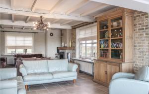 a living room with white furniture and a brick wall at Six-Bedroom Holiday Home In Lo-Reninge in Lo-Reninge