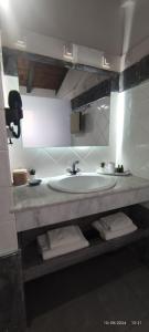a bathroom with a sink and a counter with towels at olivegrove in Sidari
