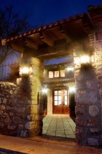 a stone building with a doorway with lights at Hotel Rural La Cabaña in Palazuelos