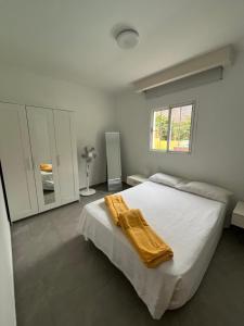 a bedroom with a bed with a yellow blanket on it at SUNNY CARMELITO DELUXE in Mogán