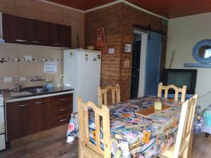 a kitchen with a table and a refrigerator at Ma-Lu-Or 2 in Trelew