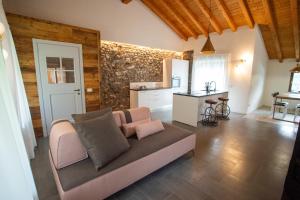 Le Cornici Home Suites - Apartments - Lake Idro في Ponte Caffaro: غرفة معيشة مع أريكة ومطبخ