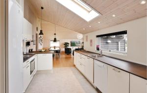 a kitchen with white cabinets and a skylight at Nice Home In Stege With Sauna in Stege