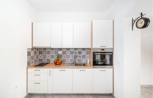 a kitchen with white cabinets and a sink at Cozy Home In Maslenica With Wifi in Maslenica