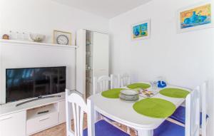a white dining room with a table and a tv at Awesome Apartment In Santa Pola in Santa Pola