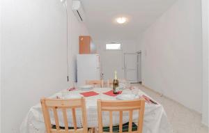 kuchnia ze stołem, krzesłami i lodówką w obiekcie 1 Bedroom Amazing Apartment In Biograd w Biogradzie na Moru