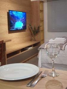 a table with a white plate and a tv on a wall at Oh Barrancas in Buenos Aires