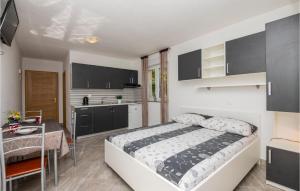 a bedroom with a bed and a table and a kitchen at Stunning Apartment In Krvavica in Krvavica