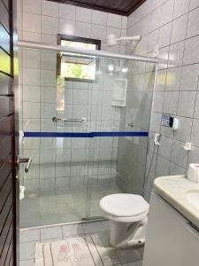 a bathroom with a glass shower with a toilet at Village Miramar in Maragogi