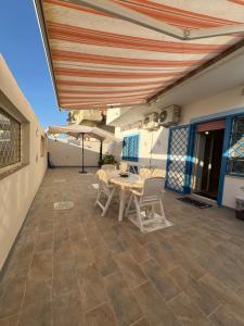 a patio with a table and chairs under awning at A mare,Pozzuoli-Licola in Licola +21 photos