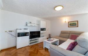 a living room with a couch and a flat screen tv at Holiday Home Rtina 24 in Rtina