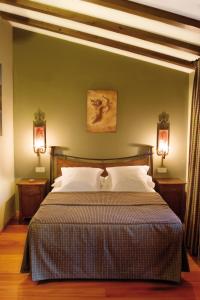 a bedroom with a large bed with two lights at Hotel Rural La Cabaña in Palazuelos