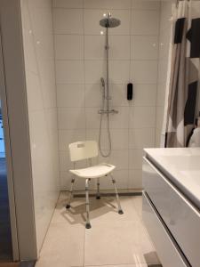 una doccia con sedia bianca in bagno di Sundaville bij Posbank Veluwe a Eerbeek Altre 16 foto