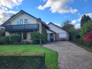 una casa con balcone in cima a un vialetto di Sundaville bij Posbank Veluwe a Eerbeek
