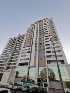 a large building with cars parked in front of it at Apto inteiro com lazer completo in Brasilia
