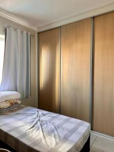 a bedroom with a bed and wooden cabinets at Apto inteiro com lazer completo in Brasilia