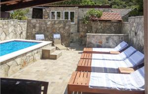 a patio with two lounge chairs and a swimming pool at Awesome Home In Zastrazisce With Wifi in Zastražišće