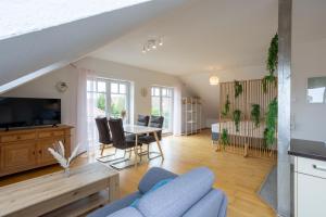 a living room with a blue couch and a table at Traumhaus mit Garten in Reppenstedt