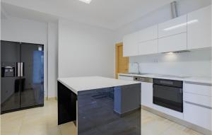 une cuisine avec des armoires blanches et un réfrigérateur noir dans l'établissement Awesome Home In Sevid With Wifi, à Sevid