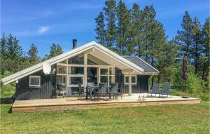 a house with a deck with chairs and a grill at Holiday Home Sikavej Oksbøl Vi in Mosevrå