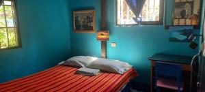 a bedroom with a bed with a blue wall at Hotel y Restaurante Playa Linda in San Pedro La Laguna