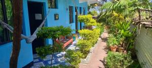 a blue house with plants on the side of it at Hotel y Restaurante Playa Linda in San Pedro La Laguna