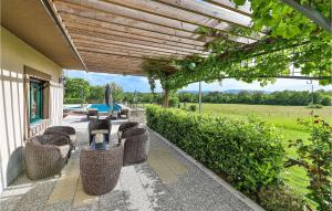 a patio with wicker chairs and tables on a building at Three-Bedroom Holiday Home In Grab in Grab