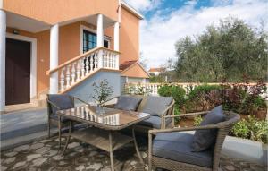patio con sillas, mesa y balcón en Beautiful Apartment In Sukosan, en Donje Raštane