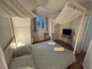 ein Schlafzimmer mit einem Bett und einem Fernseher darin in der Unterkunft Cottage avec terrasse Domaine golf de Limère prox Orléans in Ardon