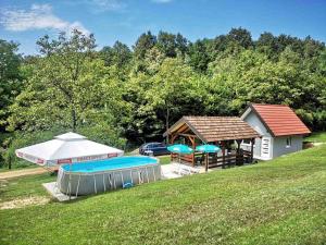 ein Pavillon und ein Haus mit Pool und Sonnenschirmen in der Unterkunft Vikendica La Anja in Laktaši