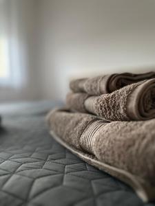 a pile of towels sitting on a bed at Apartman Fortuna in Požarevac
